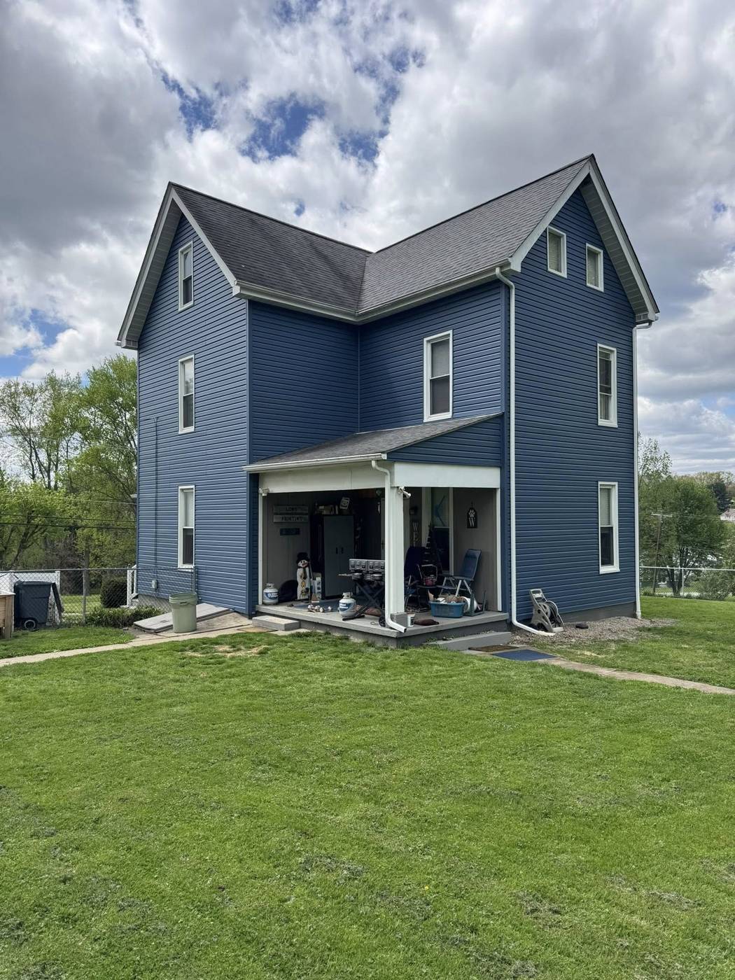 Home after full siding replacement in deep blue with white trim